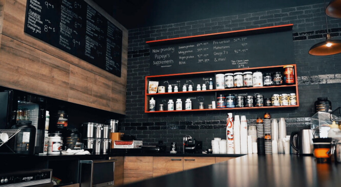 A coffee shop with a black counter and shelves.